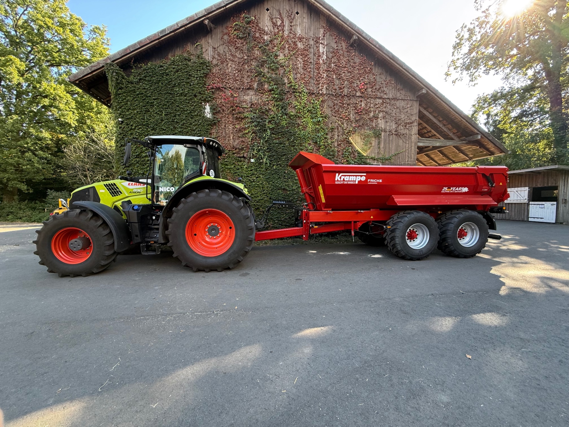 Traktor mit roter Krampe HP 20 Mulde auf dem Feld