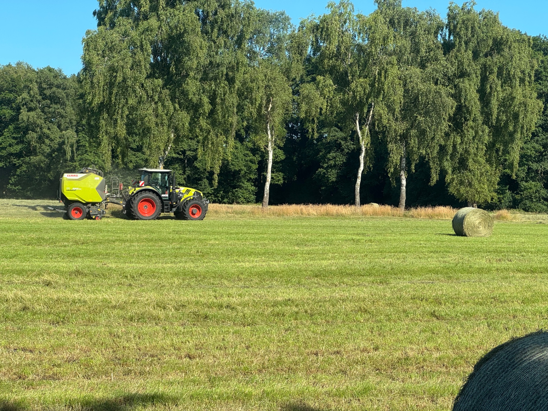 Claas-Traktor mit Ballenpresse auf dem Feld